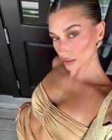 Hailey Bieber, com conjunto bege e blonzing makeup
