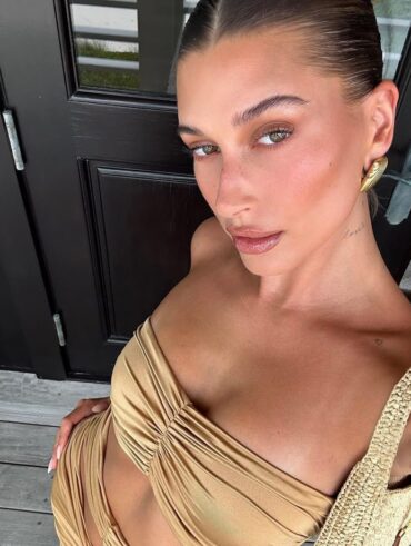 Hailey Bieber, com conjunto bege e blonzing makeup