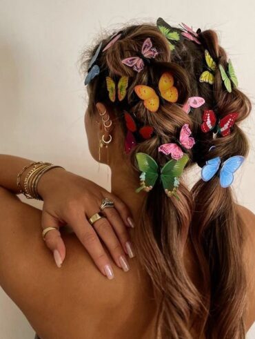 Mulher de pele clara, com cabelo claro, decorado com borboletas