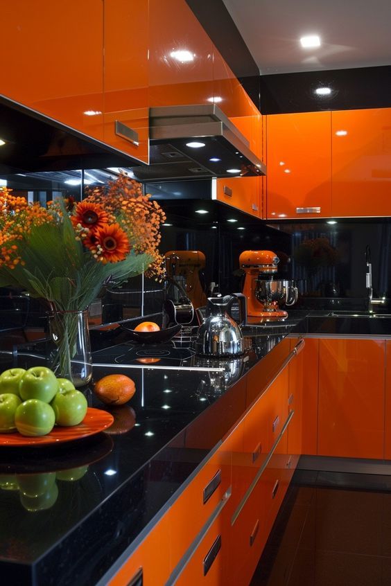 Cozinha com armários e gavetas laranja e bancada em mármore preto
