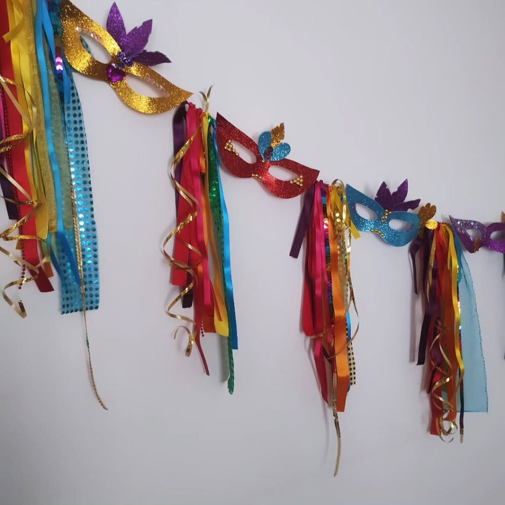 Máscaras coloridas de carnaval penduradas em um varal com fitas