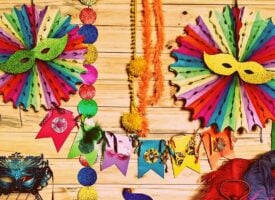 Parede com máscaras, bandeirinhas e enfeites coloridos