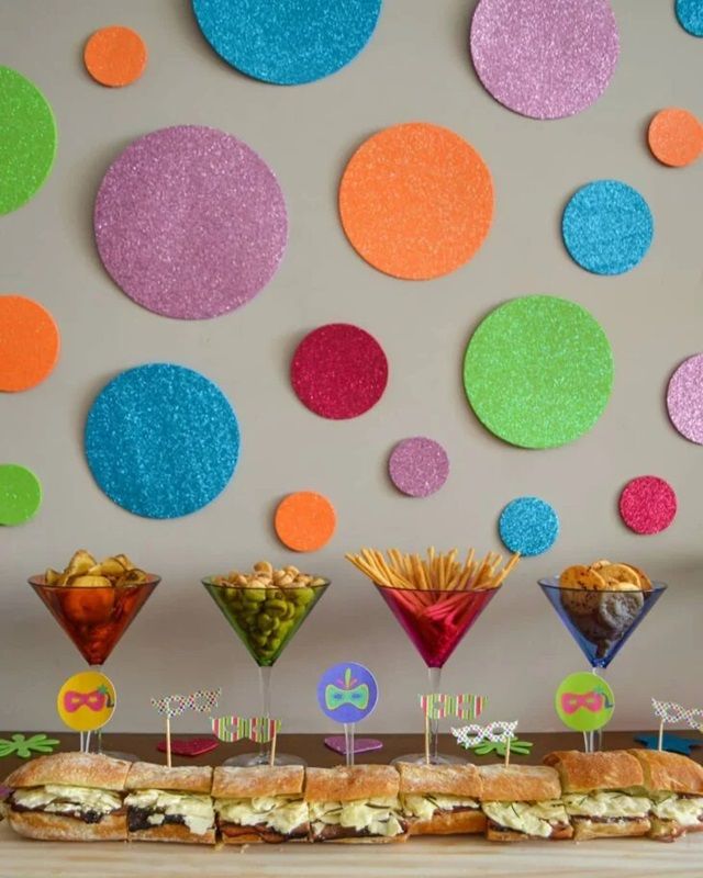 Mesa com sanduíche e taças coloridas