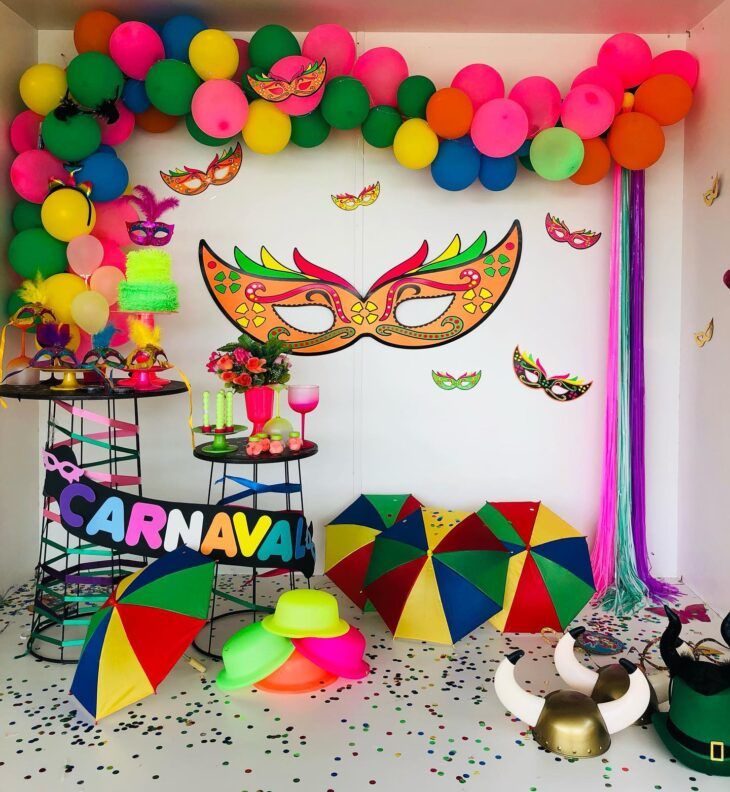 Decoração carnavalesca com balões, máscaras e guarda-chuvas coloridos