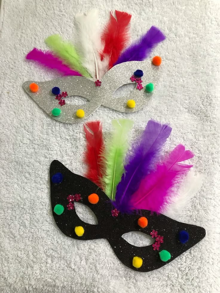 Máscaras de carnaval cinza e preta com penas coloridas