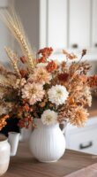 Vaso branco com alça e flores secas de tons variados