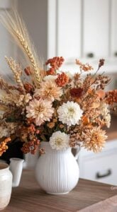 Vaso branco com alça e flores secas de tons variados
