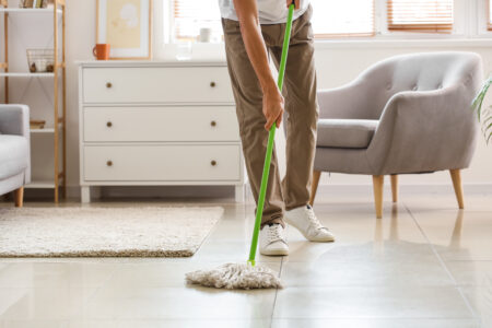 Homem limpando piso com espanador