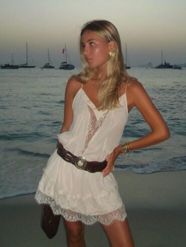 Mulher de pele clara, com look branco boho e cabelo loiro