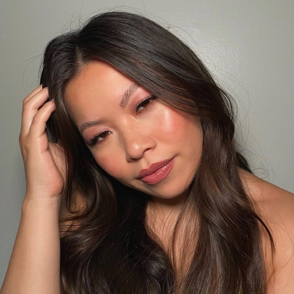 Mulher com descendência oriental, com cabelo escuro e maquiagem berry monocromática 