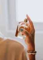 Mão de pele clara, espirrando perfume