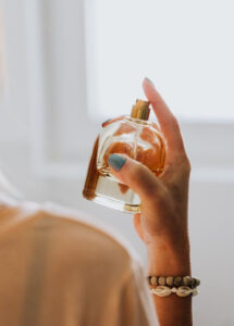 Mão de pele clara, espirrando perfume