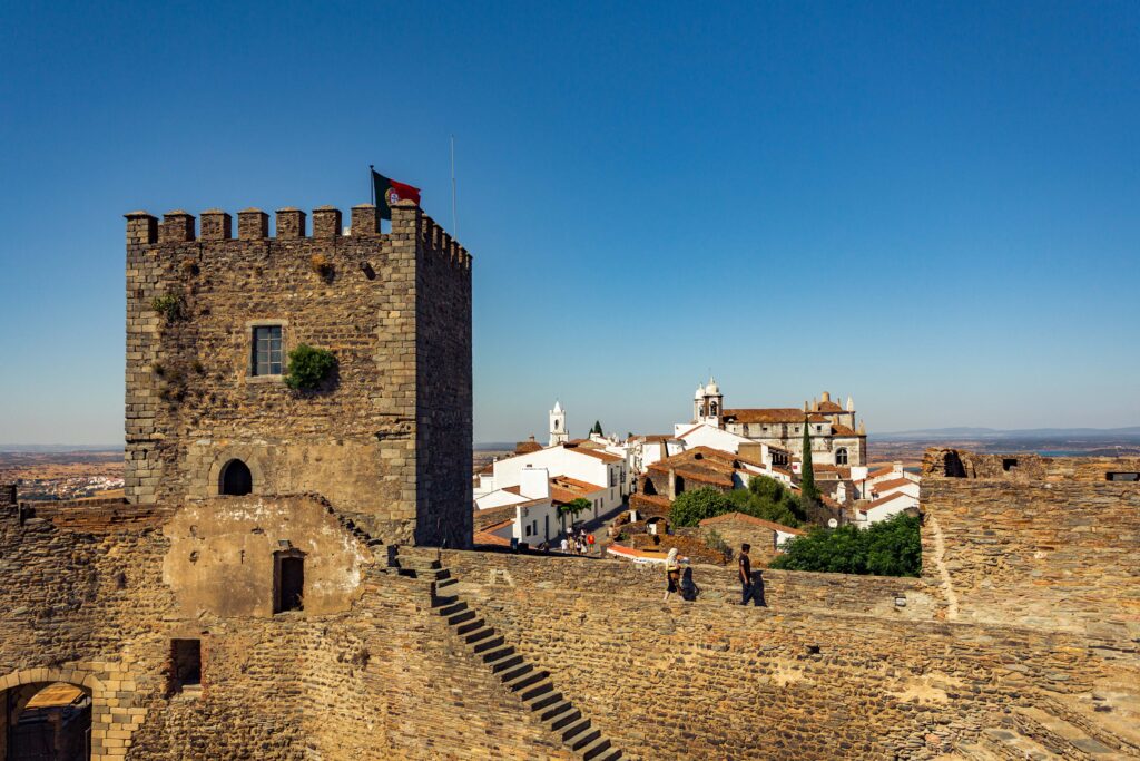 Fortaleza de um castelo medieval com casas brancas ao fundo