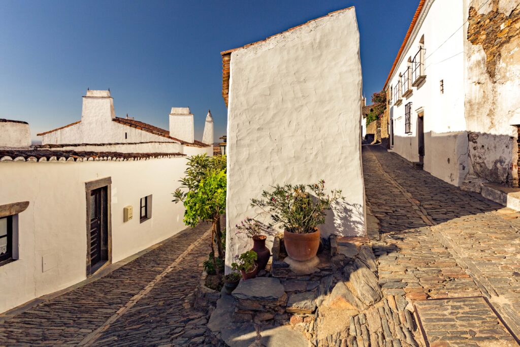 Arquitetura com ruas de pedra e casas de concreto brancas