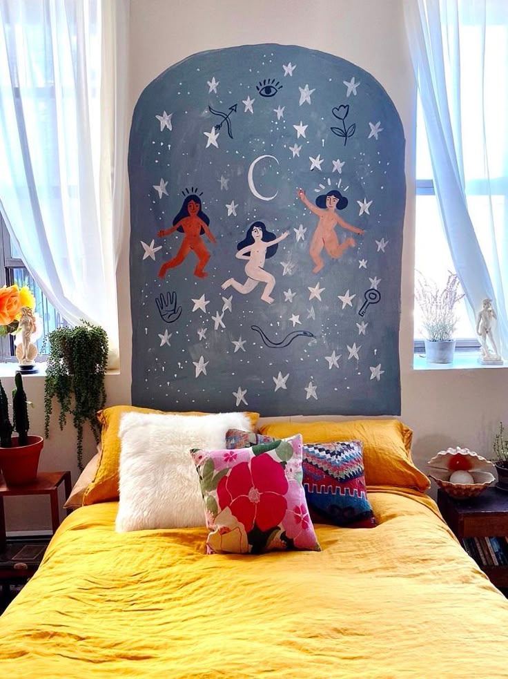 Quarto com cabeceira pintada com fundo azul, estrelas e três mulheres