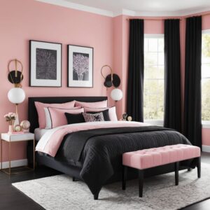 Quarto de casal com parede e roupa de cama rosa, cortina preta, e arandelas ao lado da cama