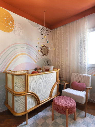 Quarto de bebê com berço, poltrona e pufe, e teto na cor Tamarindo
