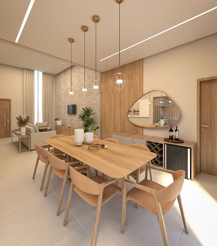 Sala de jantar em tons amadeirados neutros com espelho orgânico e pendentes de vidro
