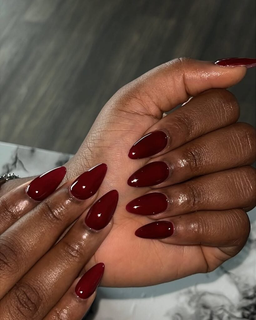 Mãos de pele preta, com unha amendoada vermelho-cereja 