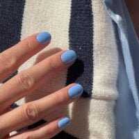 Mão de pele clara, com unha curta squoval azul-bebê