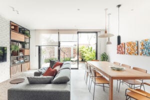 Casa com sala de estar e jantar integrada com cobogós no muro