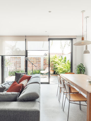 Casa com sala de estar e jantar integrada com cobogós no muro