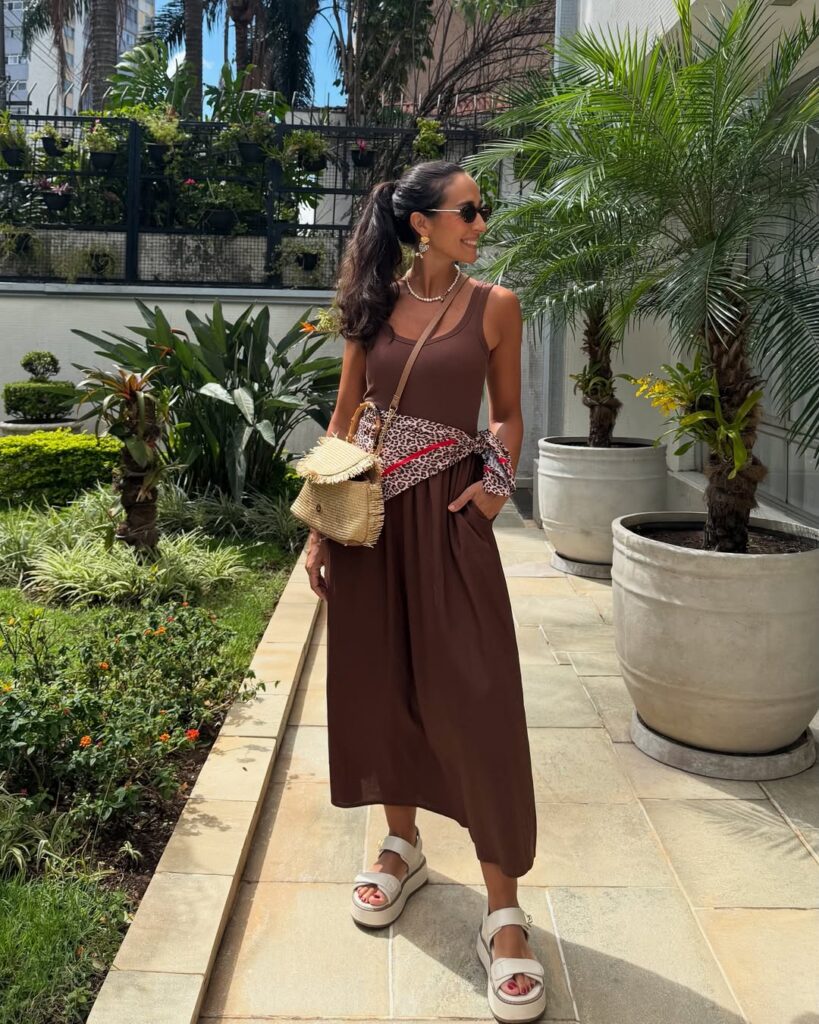 Mulher de pele clara, com vestido Mocha Mousse e lenço de onça na cintura
