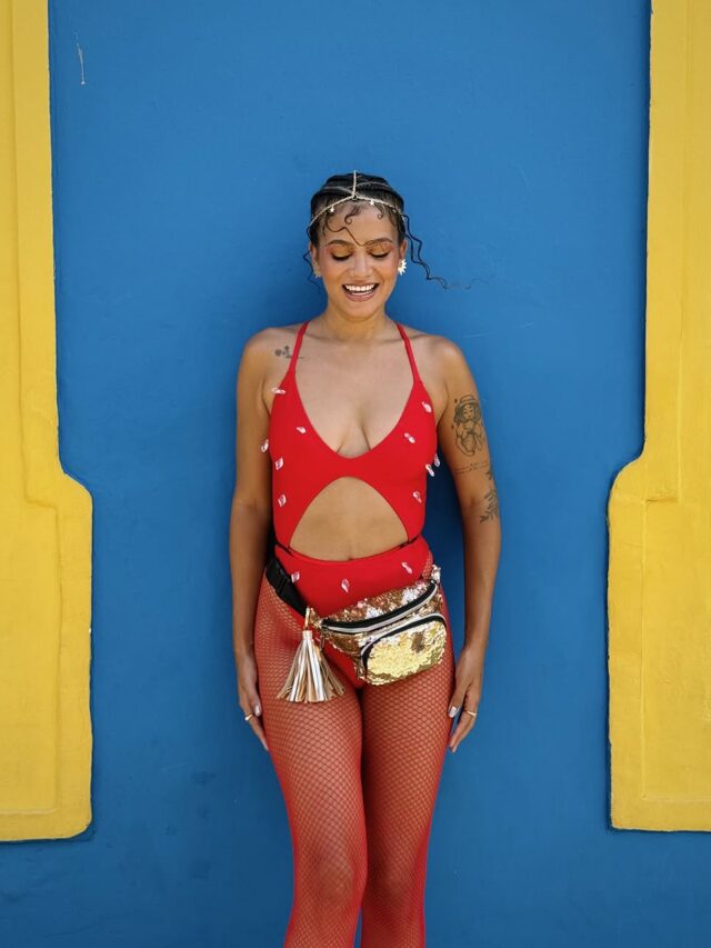 Júlia Lira, com maio vermelho, meia arrastão vermelha e pochete dourada