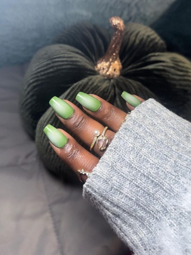Mão de pele negra, com esmalte verde e técnica aura nails