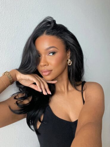 Mulher negra com cabelo longo, liso e escovado com técnica blowout hair