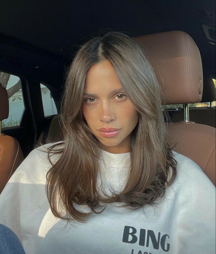 Mulher de pele clara, com blusão branco e cabelo médio com franja longa