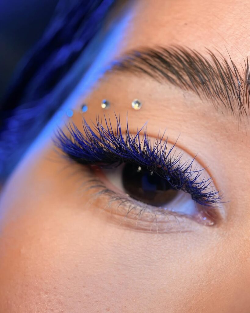 Mulher de pele clara, com cílios azul 