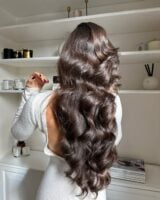 Mulher de pele clara, com vestido branco e cabelo castanho hidratado