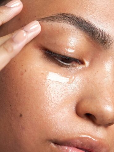 Mulher de pele clara, com creme aplicado na área dos olhos