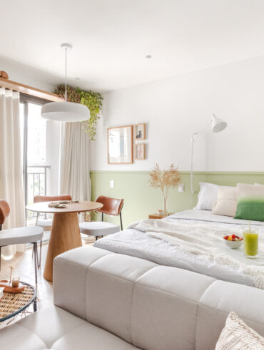 Quarto de casal com paleta de cores neutras e meia parede verde-claro