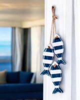 Enfeite de peixinho em branco e azul pendurados na parede
