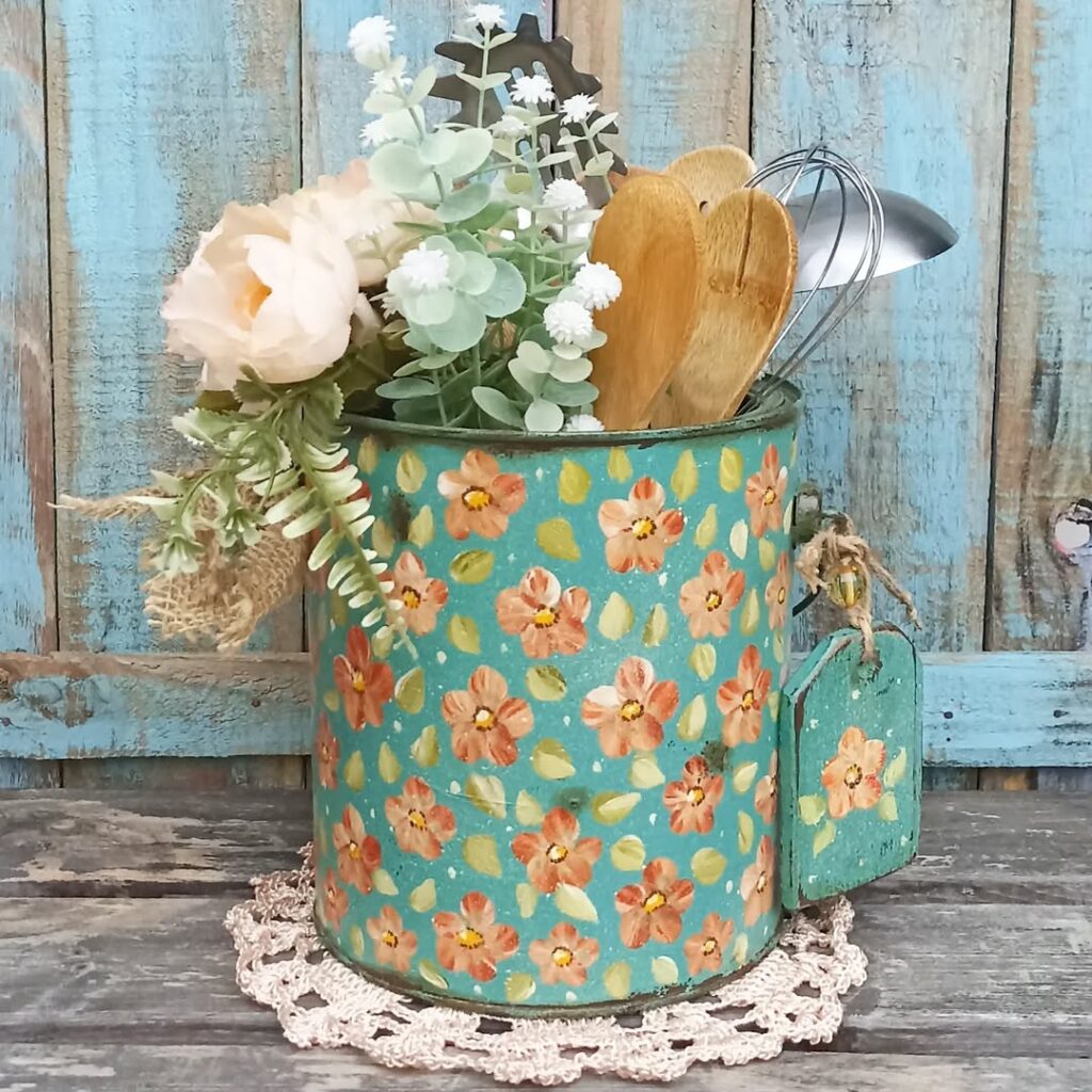 Lata decorada com fundo azul e flores rosas