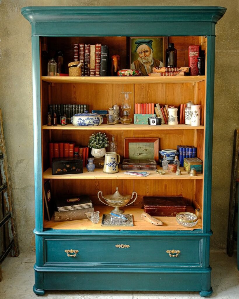 Estante de madeira azul com livros e objetos decorativos