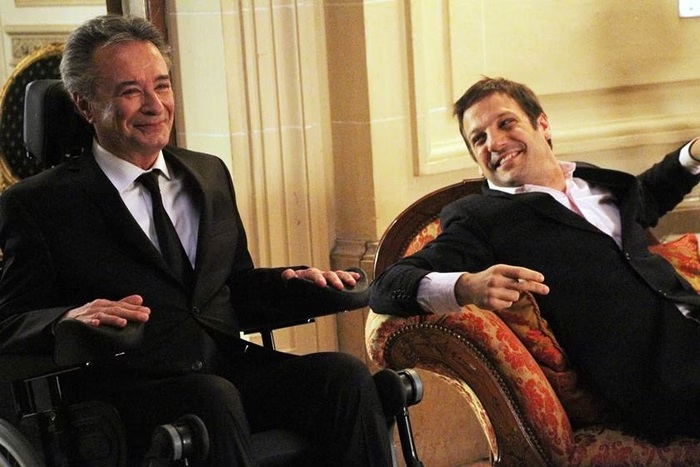 Dois homens vestidos com terno preto sentados