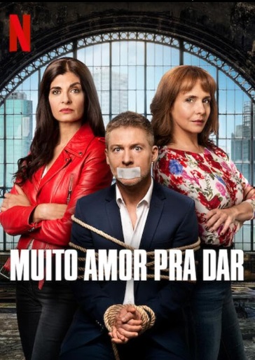 Cartaz de filme com um homem sentado e amarrado entre duas mulheres