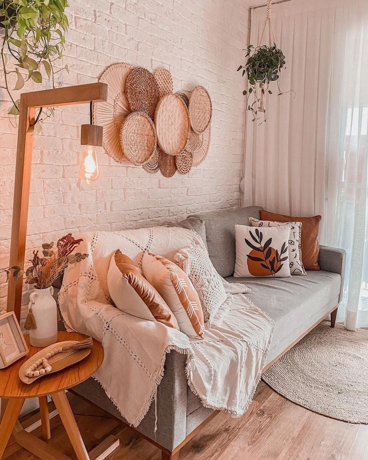 Sala de estar com sofá cinza e palha na parede