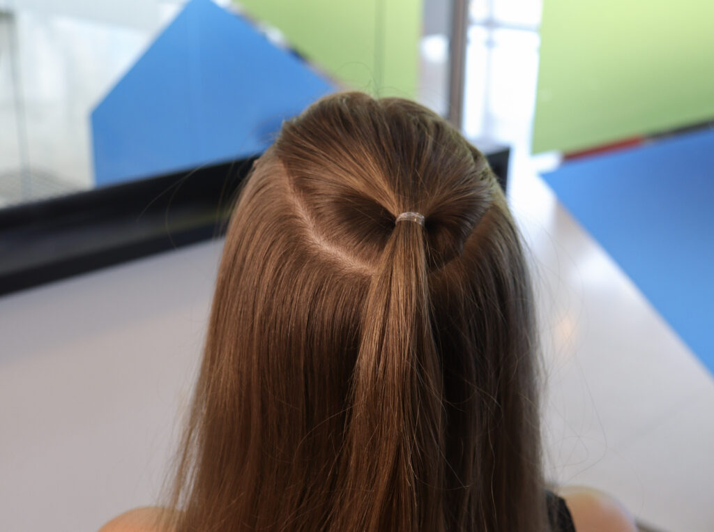 Cabelo castanho de mulher com pequeno rabo de cavalo