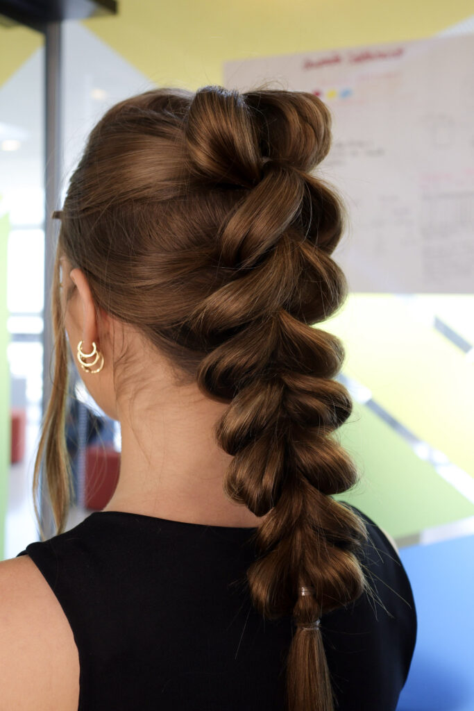 Mulher de pele clara de costas com cabelo comprido trançado
