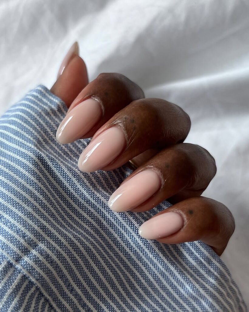 Mão de pele preta, com unha amendoada nude