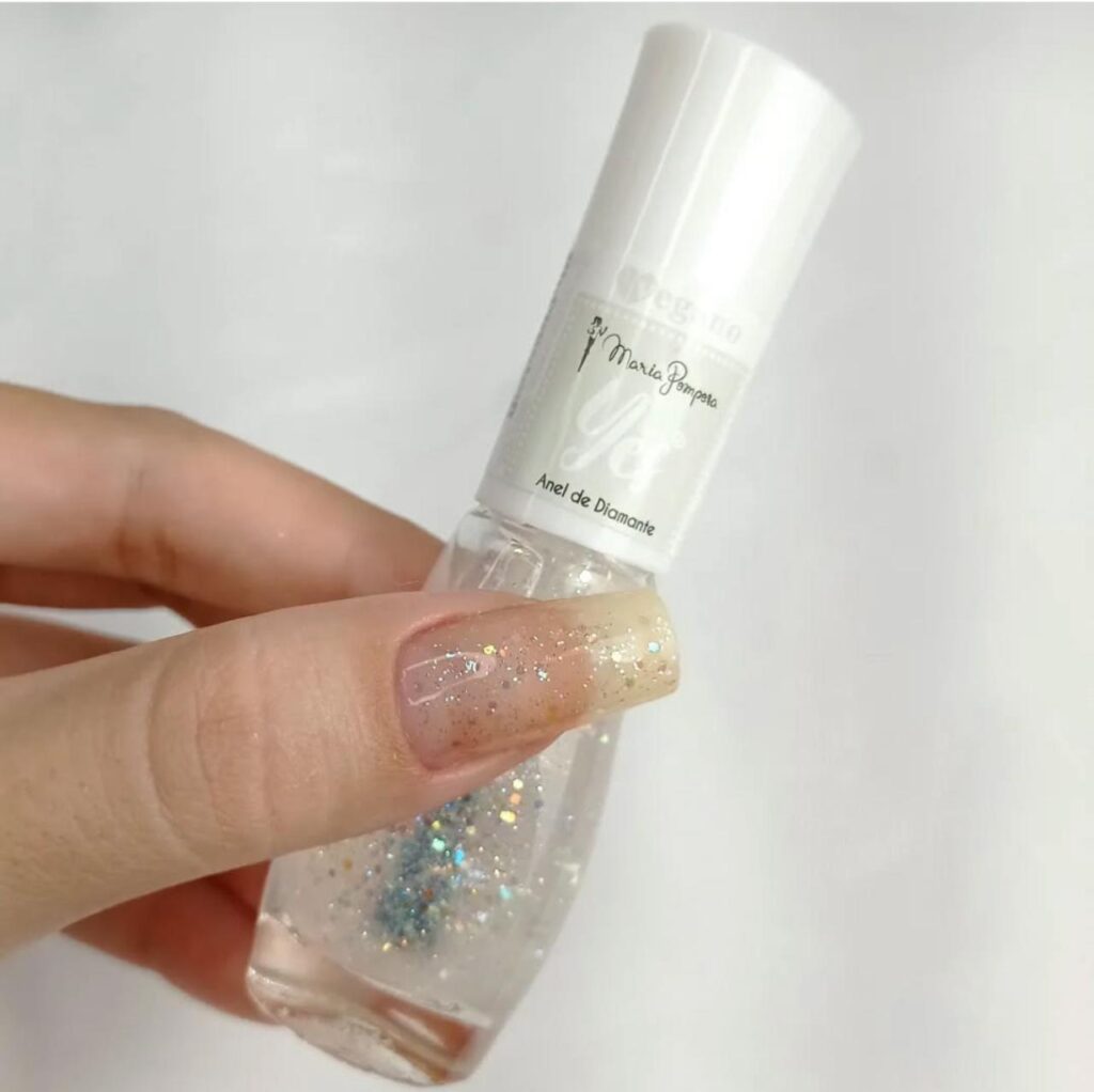 Mão de pele clara, com unha quadrada com glitter