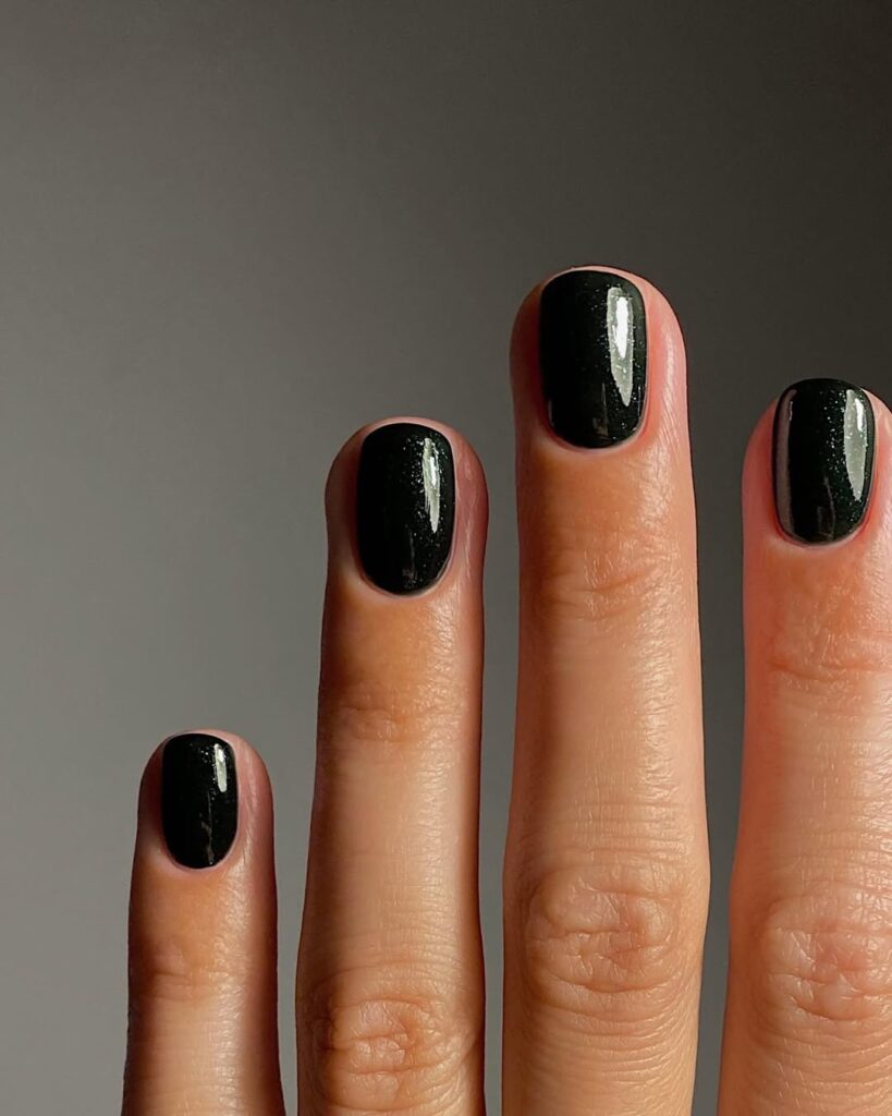 Mão de pele clara, com unha curtinha pintada com esmalte preto