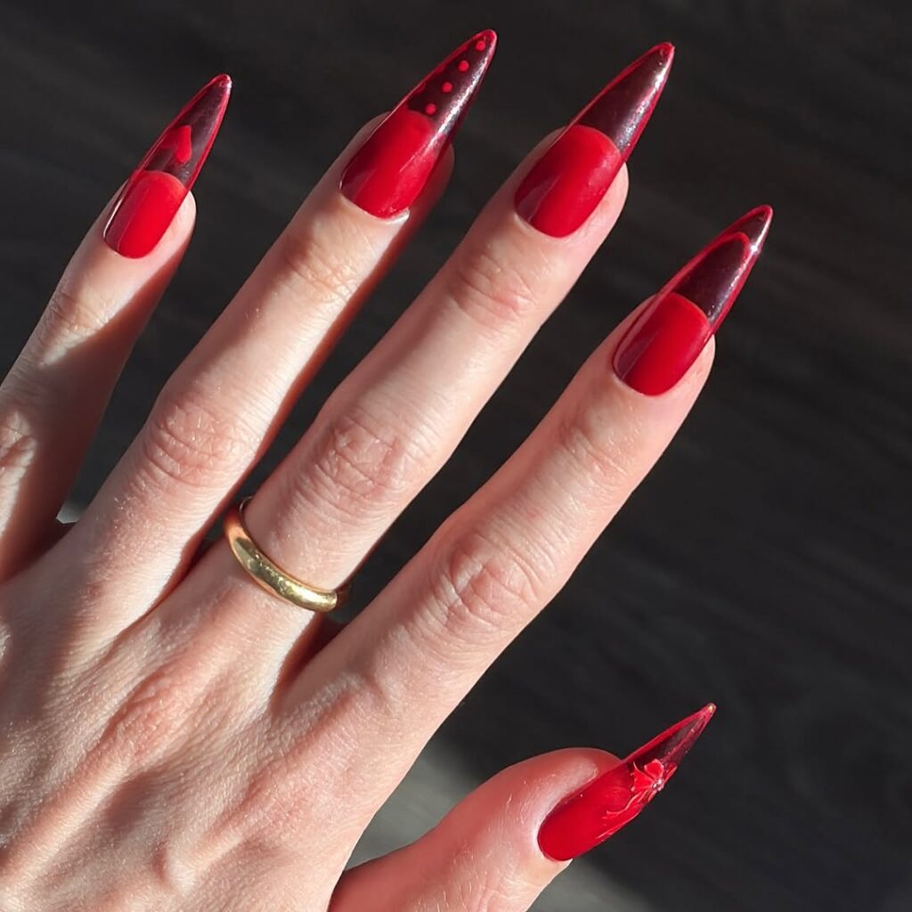 Mão de pele clara, com unha stiletto vermelho-cereja com acabamento jelly