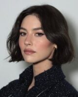 Gracie Abrams, com roupa preta, cabelo curto preto e watercolour makeup