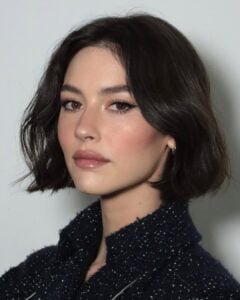 Gracie Abrams, com roupa preta, cabelo curto preto e watercolour makeup