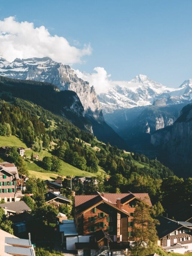 Ao fundo os Alpes Suíços, com cabanas nas montanhas verdes